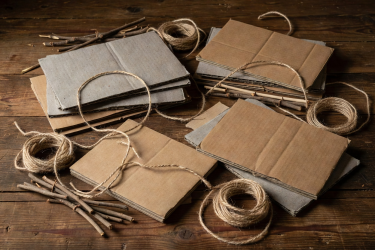 3D still life of recyclable craft boards and natural string on dark timber